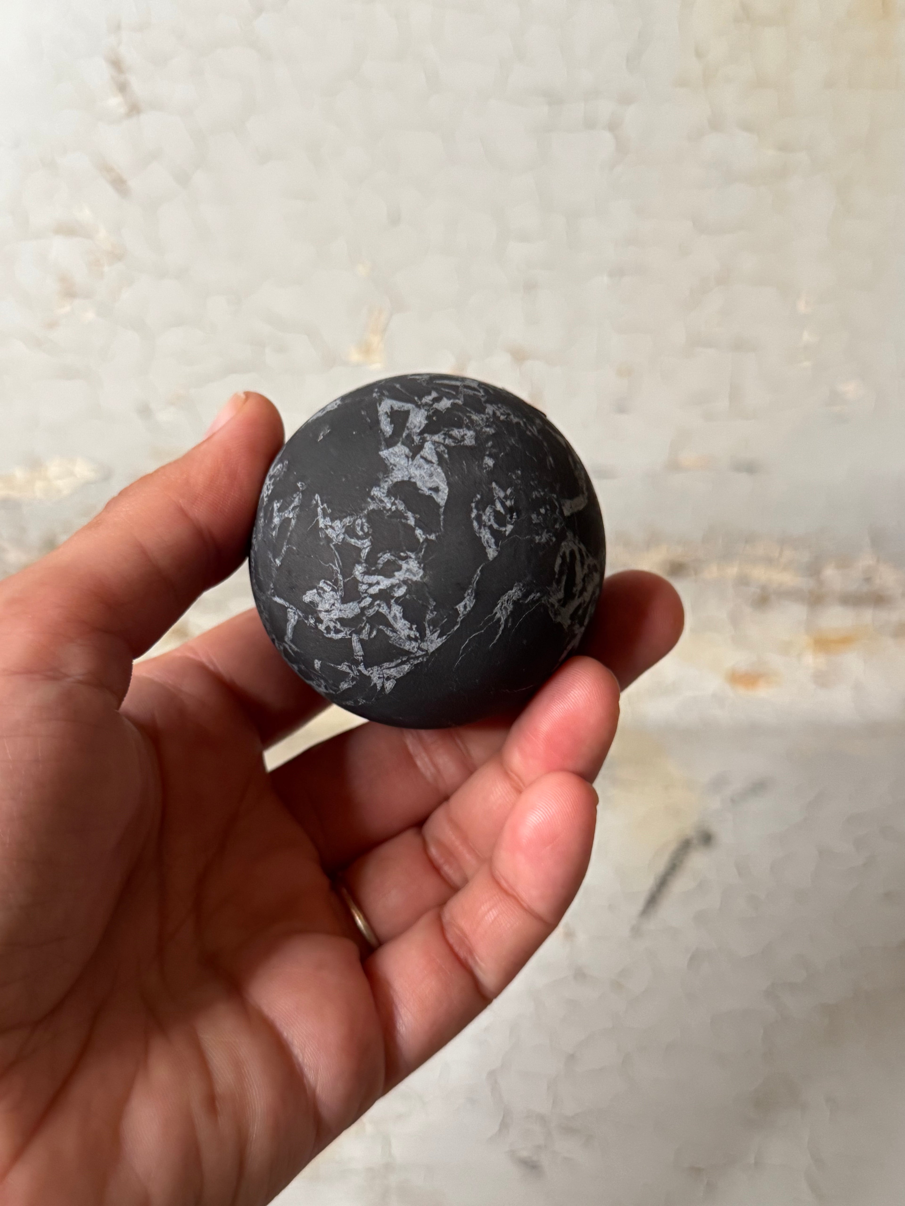 Shungite sphere with quartz veins