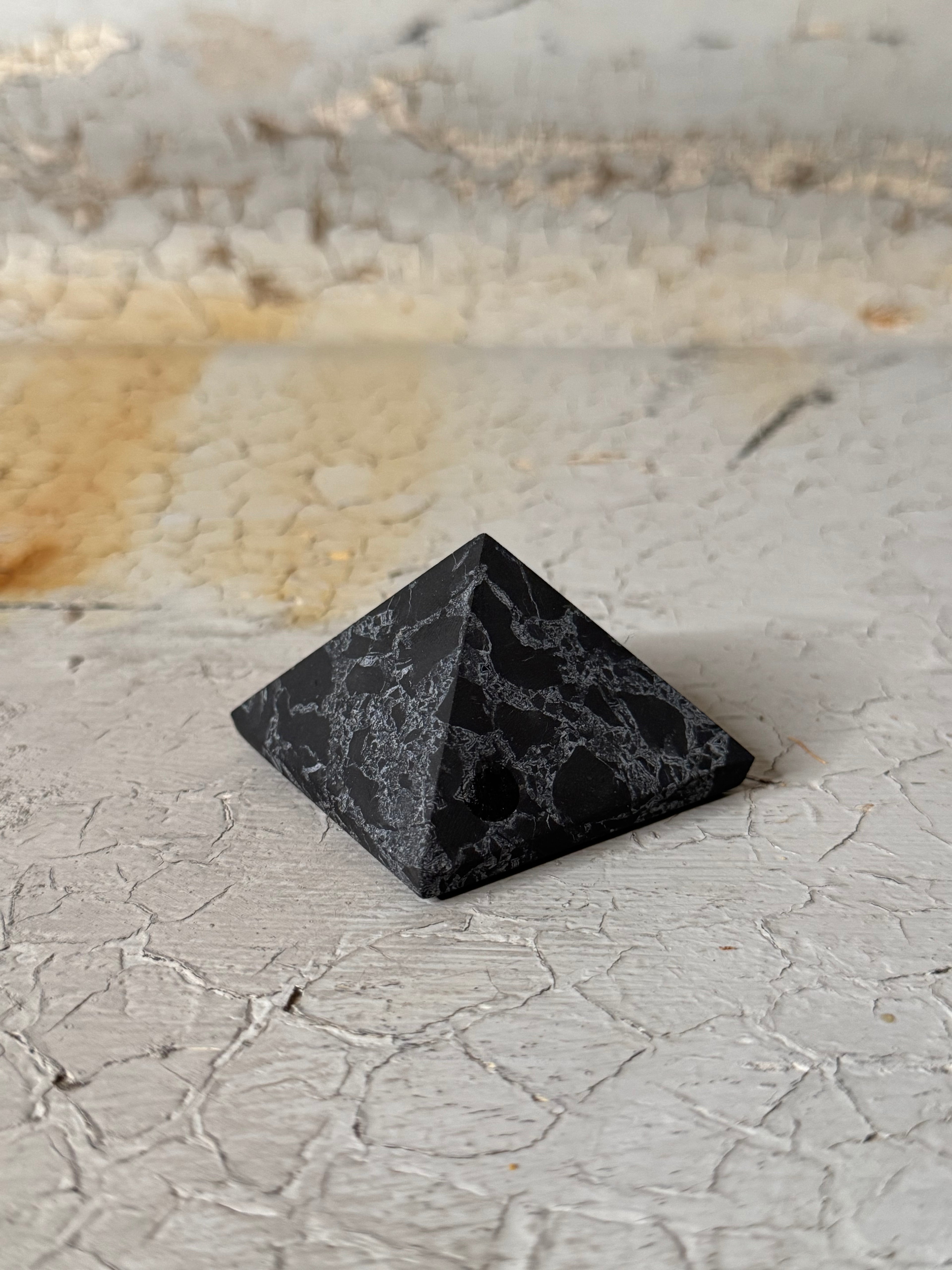 Shungite pyramid with quartz veins